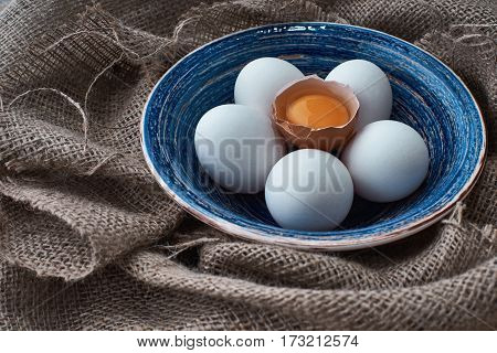 Ecological natural fresh eggs collected in the plate for cooking on the fabric.