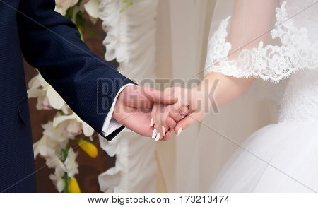 Young married couple holding hands ceremony wedding day