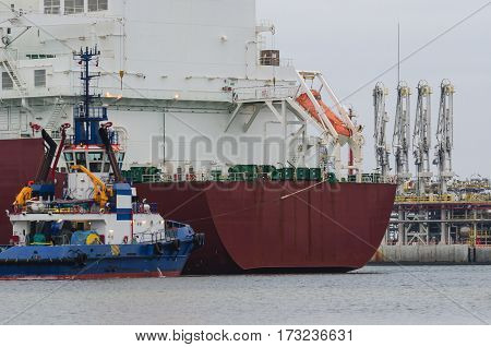 LNG TERMINAL IN SWINOUJSCIE - Tanker moored to a gas connection with the help of a tugboat