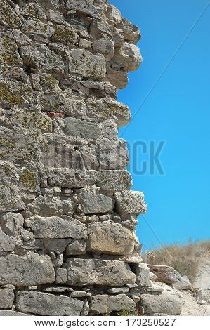 collapsed stone wall in ruins on sky background
