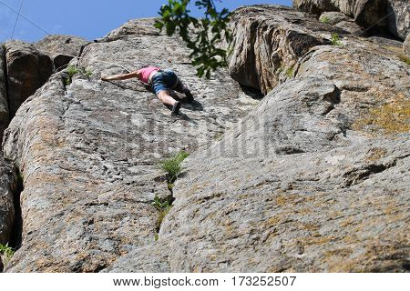 Girl rock climber climbs on the rock