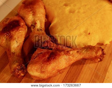 Food photography of a close up fried chicken and polenta on wooden plate