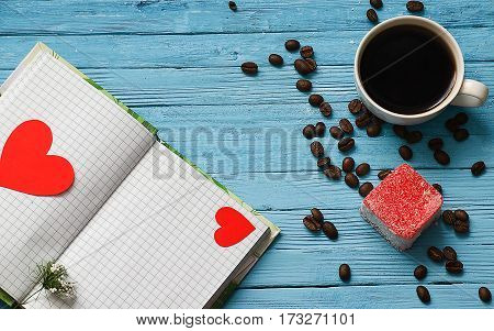 Cooked black coffee with sweet marshmallow on a blue wooden table