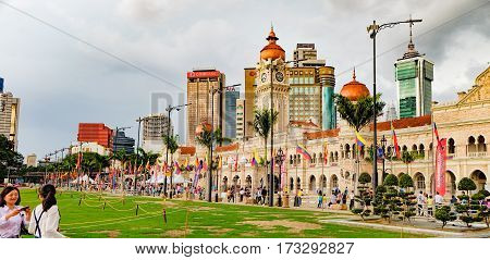 Kuala Lumpur, Malaysia - February 7, 2016: Bangunan Sultan Abdul Samad located along Jalan Raja in front of Independence Square. Asian tourists making selfie photo on smartphon in the foreground