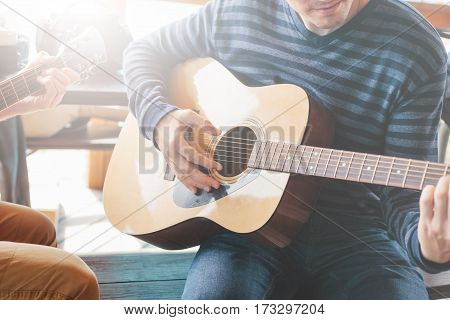 Masterclass learning to play the guitar outdoors. Musical education.