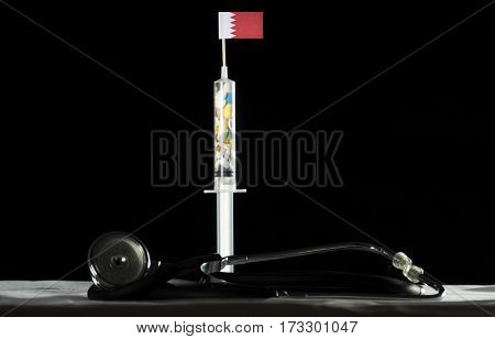 Stethoscope And Syringe Filled With Drugs Injecting The Bahraini Flag On A Black Background