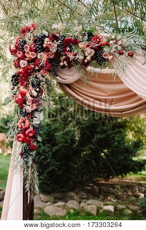 Autumnal Wedding Arch Decoration Of Roses, Apples, Grape And Pomergranate, In Red Colour, Closeup
