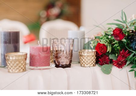 Beautifully Composition Of Candles And Red Flowers On Table