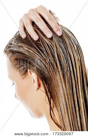 Photo of woman applying hair conditioner.
