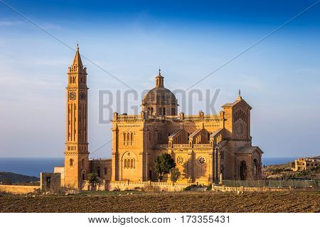 Gozo Malta - The Basilica of the National Shrine of the Blessed of Ta' Pinu at sunset with clear blue sky on a summer day