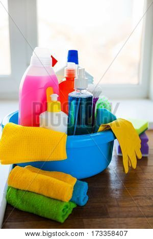 Basket With Cleaning Items On Blurry Background White Citchen. Cleaning Concept.
