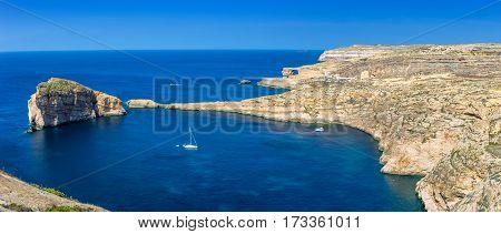 Gozo Malta - Panoramic skyline view of Dwejra bay with Fungus Rock Azure Window and sailboat on a nice hot summer day