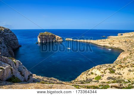 Gozo Malta - Panoramic skyline view of Dwejra bay with Fungus Rock Azure Window and sailboat on a nice hot summer day