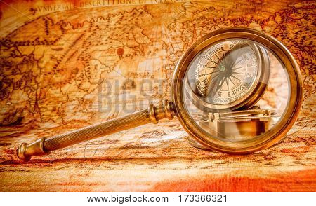 Vintage still life. Vintage magnifying glass lies on an ancient world map in 1565.