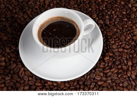 white cup of coffee beans at coffee beans