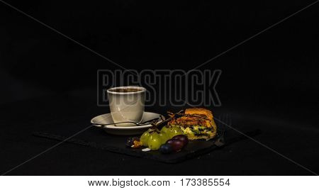 tasty spinach and ricotta quiche aromatic black coffee in a cup of cream white and red grapes lunch set