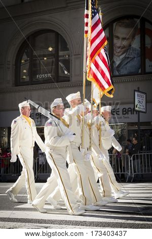 NEW YORK - 11 NOV 2016: Vets in white uniforms from the American Legion Honor Guard carry the American Flag in Americas Parade up 5th Avenue on Veterans Day in Manhattan.