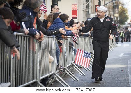 NEW YORK - 11 NOV 2016: US Navy, USN personnel from the USS Iwo Jima shakes hands with spectators during the Americas Parade up 5th Avenue on Veterans Day in Manhattan.