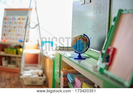 The Classroom In Kindergarten With School Desks And Chairs.