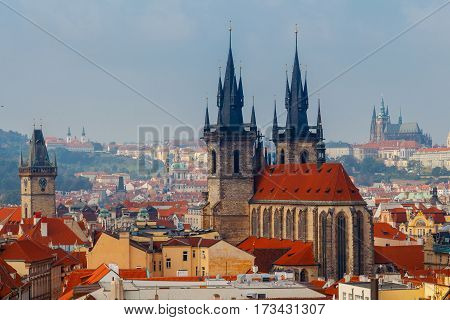 Aerial view of the historic center of Prague with towers spiers and red-tiled roofs.