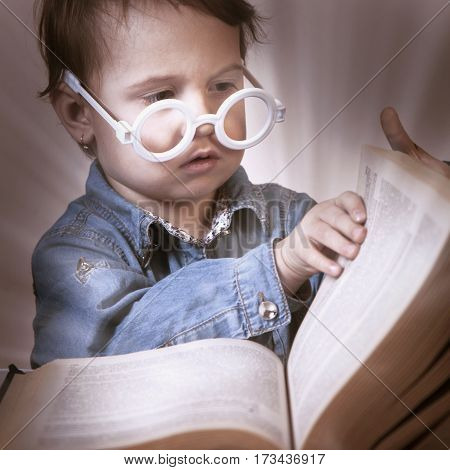 Girl child reading a magic book. (Education knowledge wisdom magic childhood concept)