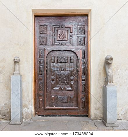 Cairo, Egypt - February 18, 2017: Wooden aged engraved decorated door and stone wall, El Harawi historical house, Medieval Cairo Egypt