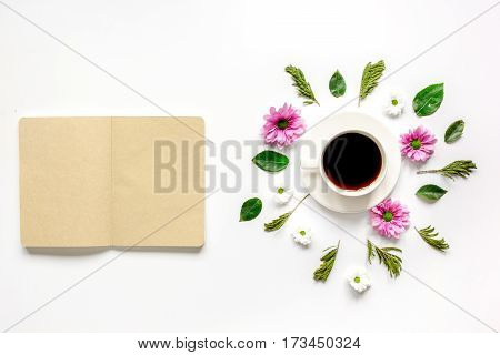 Froral flat lay with cup of coffee and craft notepaper on white background top view mockup