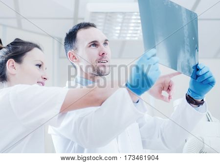 X Ray Imaging Consulting by Medical Staff in the Hospital Room. Satisfied Smiling Doctor Pleased with the Scanning Results.