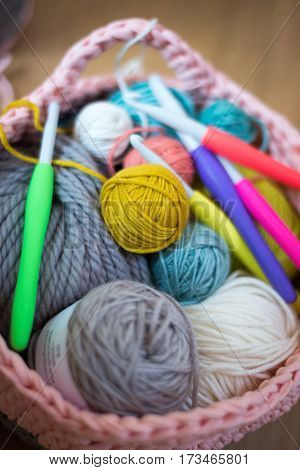 Balls Of Yarn And Crochet Needles In Knitted Woolen Basket