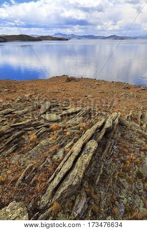 Destroyed and cracked by nature boulders by the lake