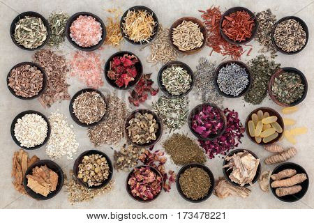 Herbs and ingredients to heal and soothe skin disorders such as psoriasis and eczema on hemp paper background.