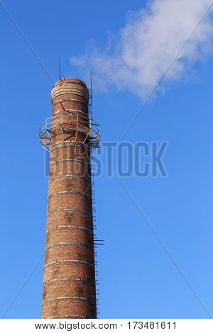 Smoke from pipe on a background of clear sky