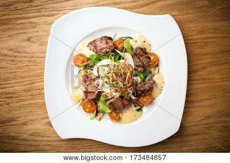 Brutus salad with beef tenderloin served on a plate
