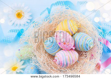 Easter colorful eggs background. Beautiful colorful eggs with decorations over blue wooden background, border design in pastel colors