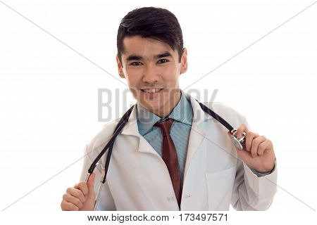 cheerful young man doctor in uniform with stethoscop on his neck looking and smiling on camera isolated on white