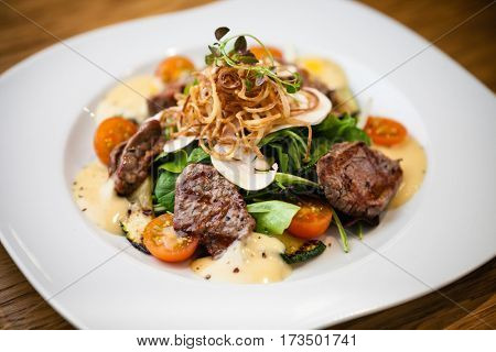 Brutus salad with beef tenderloin served on a plate