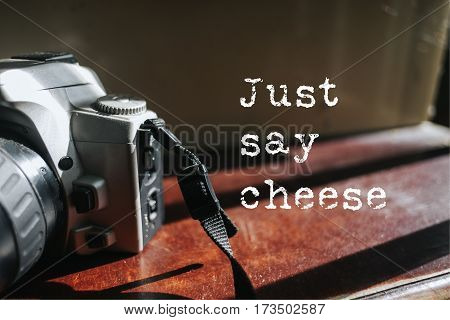 Isolated calligraphy on Camera film on brown wooden stairs. Quote about photo and photography. Just say cheese.