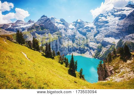 Panorama of the azure pond Oeschinensee. Popular tourist attraction. Picturesque and gorgeous scene. Location Swiss alps, Kandersteg, Bernese Oberland, Europe. Instagram toning effect. Beauty world.