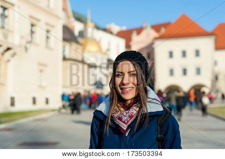 Young woman tourist in the city of Kracow , Poland, visiting the city and taking a picture in front of a famos church.