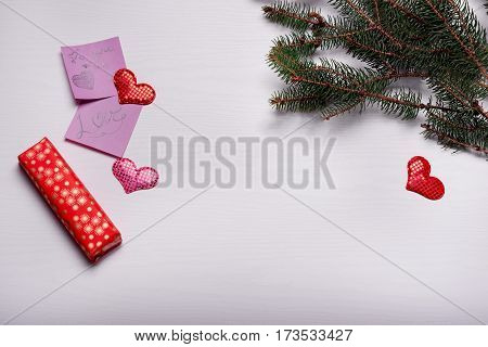 Wooden White Background With A Branch Of Pine And Three Hearts.
