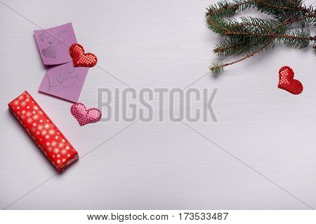 Wooden White Background With A Branch Of Pine And Three Hearts.