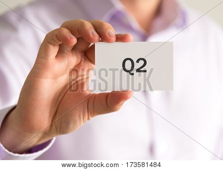 Businessman Holding A Card With Q2 Quarter 2 Message