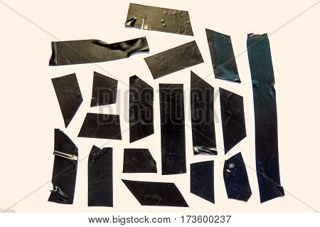 A collection of used black adhesive tape pieces