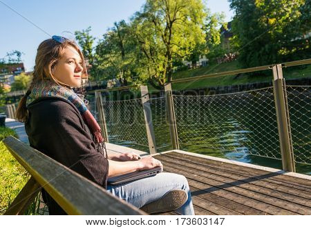 Young and attractive woman meditating with closed laptop. Feeling free.