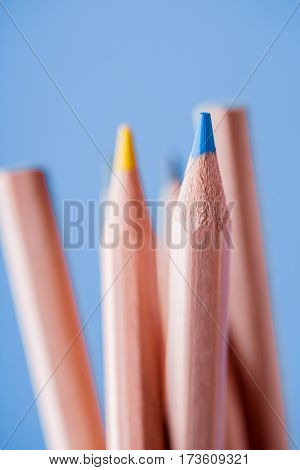 Macro view of crayons. Colored Pencils. Colored pencils on the blue background. Tips of the pencils. Drawing and painting. Artist. Blur.