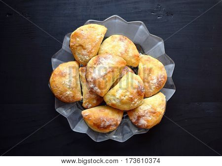 Homemade buns stuffed with jam on a black wooden background