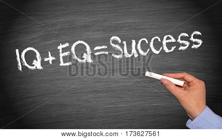 IQ plus EQ = Success - female hand writing text on chalkboard