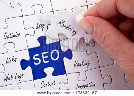 SEO - Search Engine Optimization - puzzle with text and female hand