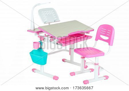 Pink chair pink school table blue basket and desk lamp on the white isolated background.