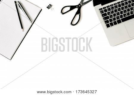 White office desk frame with laptop keyboard and supplies. Laptop, notebook, pen, clips, pencil and office supplies on white background. Flat lay, top view, mockup